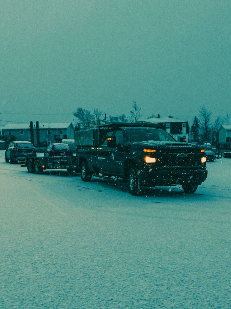 Trucks and cars navigating a snow-covered highway illustrating towing safely in bad weather