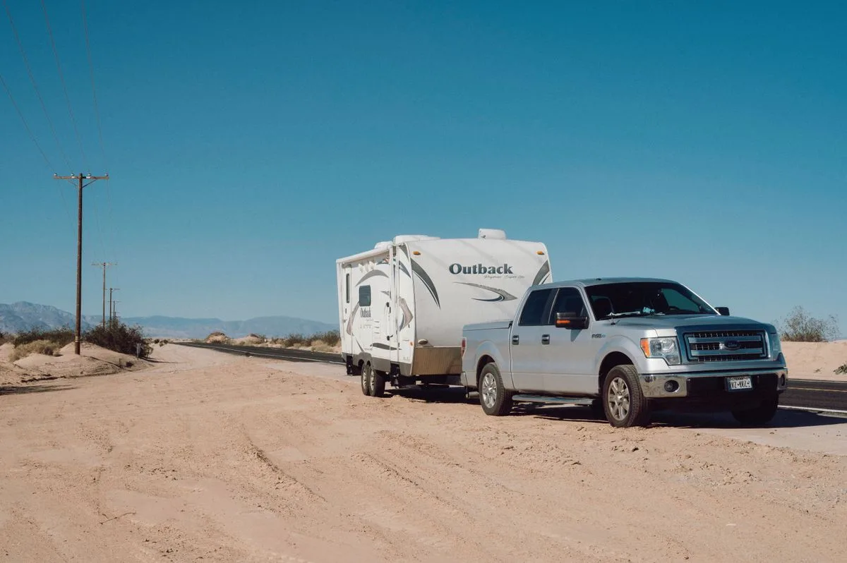Pickup truck towing a travel trailer, illustrating trailer wheel alignment