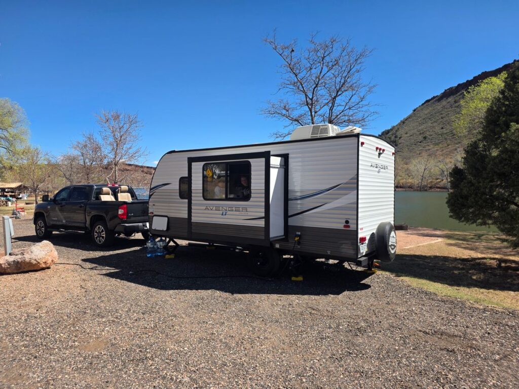 Pickup truck with travel trailer at a campsite illustrating proper weight distribution hitch setup